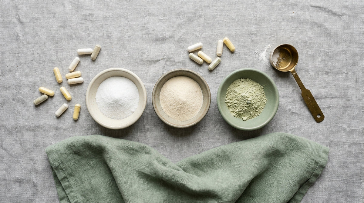 Dishes of supplement powders with scoop and capsules